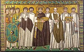A crowned man holding a bowl, surrounded by clerics, courtiers and guardsmen